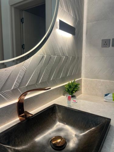 a bathroom sink with a large mirror above it at شاليه اغصان الباحة in Al Baha