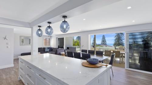 a kitchen and living room with a table and chairs at Avoca Dream in Avoca Beach
