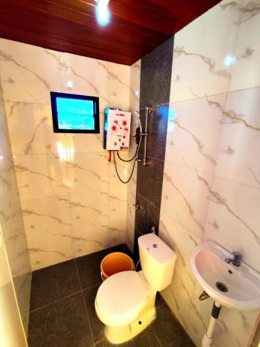 a bathroom with a toilet and a sink at Glamping Dieng New in Diyeng