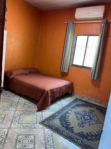 a bedroom with a bed and a window and a tile floor at Casa dos Lopes in Presidente Figueiredo