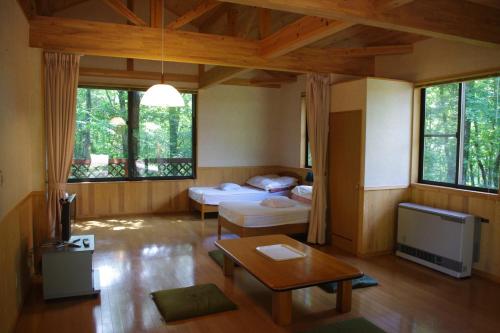 a living room with two beds and a tv at Katamaeyama Forest Park Cottage TypeC in Senboku