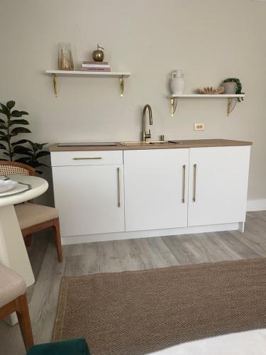 a kitchen with white cabinets and a sink at The Tamara Suite in Pensacola