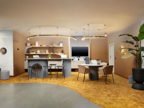 a kitchen and dining room with a table and chairs at ibis London Earls Court in London