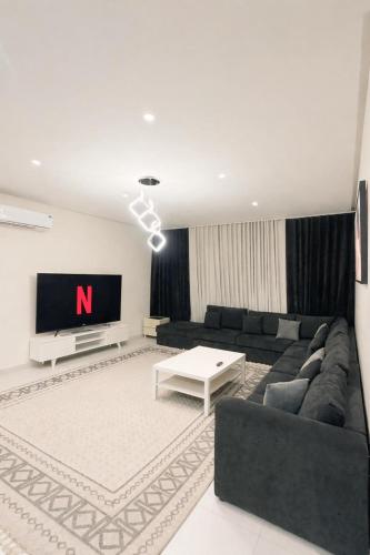 a living room with a couch and a tv at الواحه ريزدنس in Medina