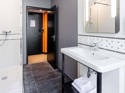 a bathroom with a sink and a mirror at ibis Styles Dinan Centre Ville in Dinan