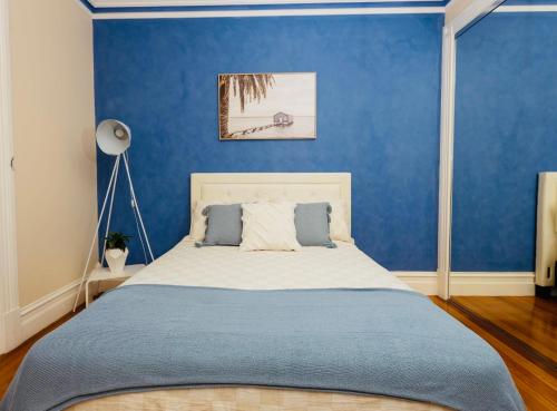 a bedroom with a bed with a blue wall at ABC Beachside Retreat in Rosebud