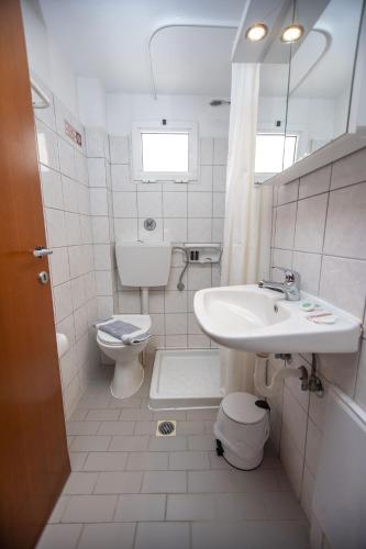 ein weißes Badezimmer mit Waschbecken und Toilette in der Unterkunft Hotel Strimoniko in Asprovalta