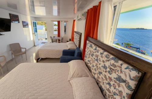 a bedroom with two beds and a view of the ocean at Posada Three Cay Suites in Providencia