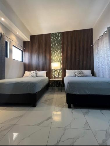 a hotel room with two beds and a window at DEPARTAMENTO CON TERRAZA Y VISTA para 6 personas in Chihuahua