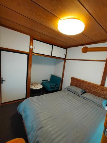 a bedroom of a boat with a bed and a chair at Nara House R2 in Kawagoe