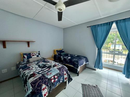 a bedroom with a bed and a window at Turtle Sands Holiday Home in Richards Bay