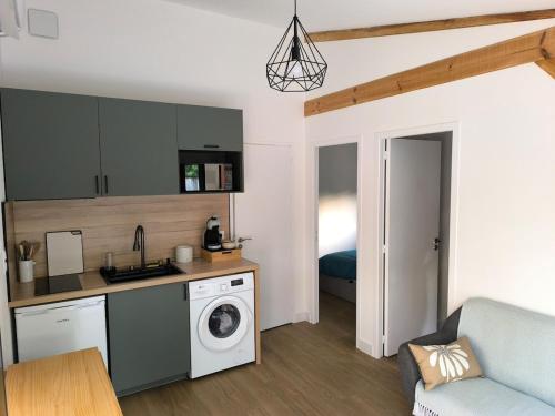 a kitchen with a sink and a washing machine at Studio indépendant face à la forêt in Aureilhan