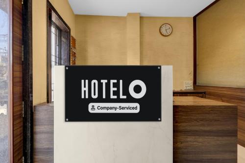 a sign in a room with a clock on a wall at Super Hotel O Navasari Bus Terminal Formerly Jay Shankar in Sisodra
