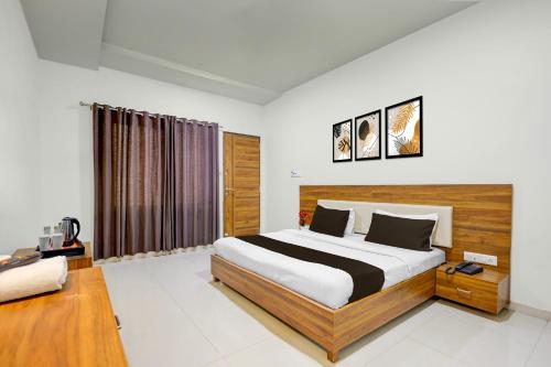 a bedroom with a large bed and a window at Super Hotel O Navasari Bus Terminal Formerly Jay Shankar in Sisodra
