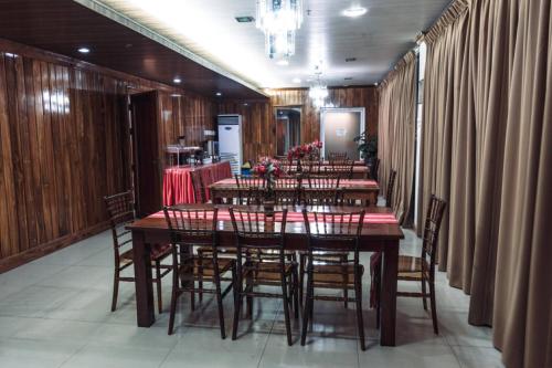 a dining room with a long table and chairs at HOTELINDA Suites in Vigan