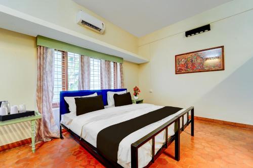 a bedroom with a large bed in a room at Super Hotel O CSIR Pappanamcode Formerly Ambadi Guest House in Poojapura