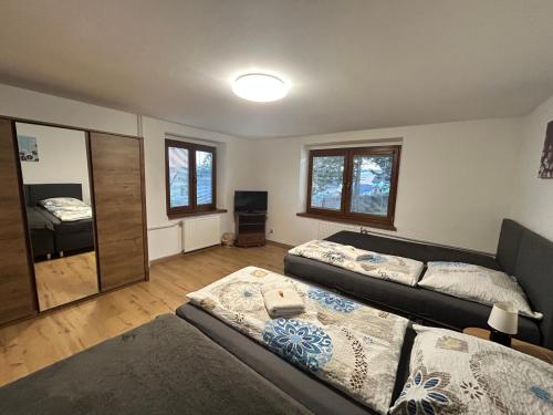 a living room with two beds and a mirror at Privát Tatry Štrba Vysoké Tatry in Štrba