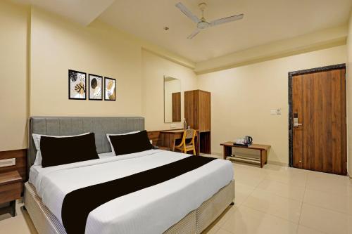 a bedroom with a large bed and a table at Townhouse Vadodara Railway Station Road Formerly Hotel Raajpath in Vadodara