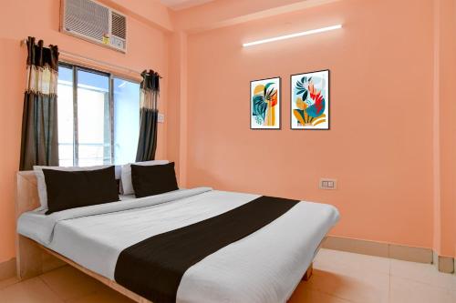 a bedroom with a large bed with orange walls at Hotel O Tarapith Temple Formerly Prerana 2 in Tarapith