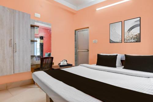 a bedroom with a large bed with orange walls at Hotel O Tarapith Temple Formerly Prerana 2 in Tarapith