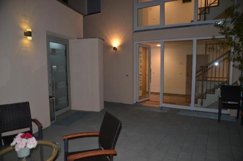 a room with chairs and a table and a building at Seebrise mit Musik und Wein in Meersburg