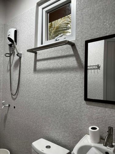 a bathroom with a sink and a mirror and a toilet at Estellie Resthouse in Maya