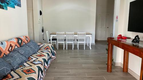 a living room with a couch and a table with chairs at Cha-am Mountain View Nature House 3 Bed 2 Bath in Phetchaburi