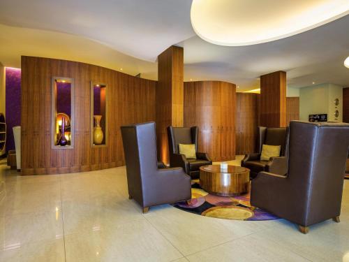 a lobby with chairs and a table in a building at Novotel Suites Mall Avenue Dubai in Dubai