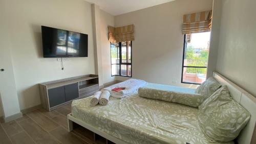 a living room with a couch and a flat screen tv at Cha-am Mountain View Nature House 3 Bed 2 Bath in Phetchaburi