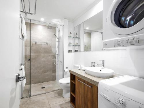 a white bathroom with a sink and a shower at The Sebel Busselton in Busselton