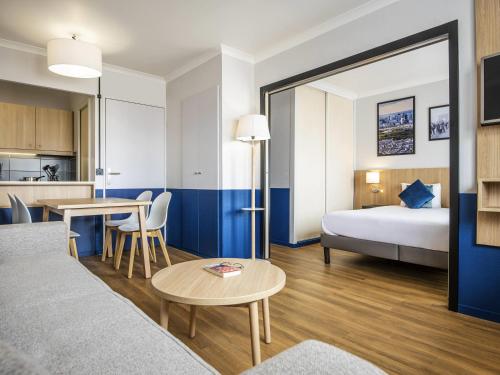 a hotel room with a bed and a table at Aparthotel Adagio La Défense Kléber in Courbevoie