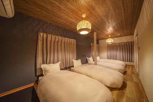 three beds are lined up in a room at 民泊-天- in Beppu