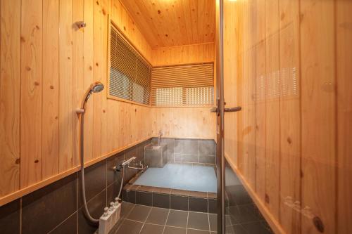 a bath room with a shower in a wooden bathroom at 民泊-天- in Beppu