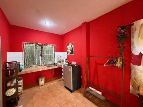 a red kitchen with a refrigerator and a red wall at Rose bungalow at Ya Nui beach in Nai Harn Beach