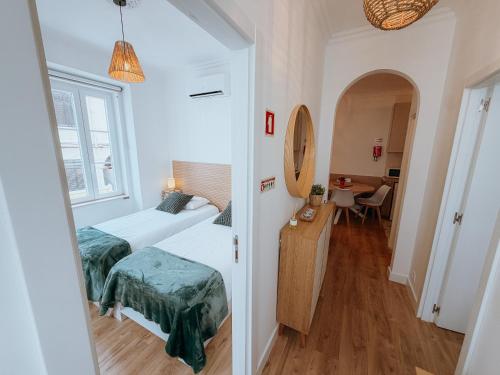 a small room with two beds and a table at Sol e Rio in Setúbal