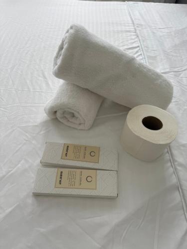a towel and a roll of toilet paper on a bed at Suite Escape Mactan , condo with balcony near Mactan Newtown and Mactan Airport in Mactan
