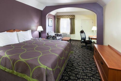 a hotel room with a bed and a desk at Super 8 by Wyndham Fairfield Tx in Fairfield