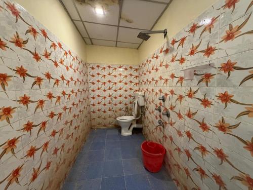 a bathroom with a toilet with flowers on the wall at Harmony - Havelock Island in Havelock Island