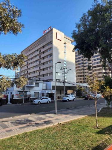 a hotel building with cars parked in front of it at ibis Antofagasta in Antofagasta
