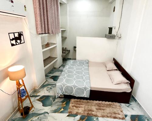 a small bedroom with a bed and a tiled floor at The Boho House in Darbhanga
