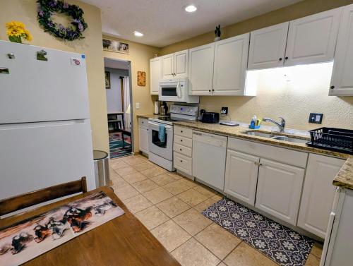 a kitchen with white cabinets and a white refrigerator at By State Fair 5 bedrooms 2 baths in Des Moines