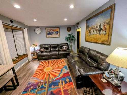 a living room with a leather couch and a table at By State Fair 5 bedrooms 2 baths in Des Moines