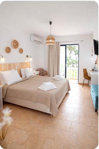 a bedroom with a bed and a desk and a window at Afroditi Junior Suites in Archangelos