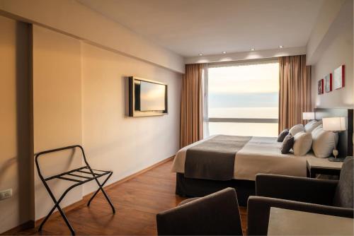 a hotel room with a bed and a window at Dazzler by Wyndham Puerto Madryn in Puerto Madryn