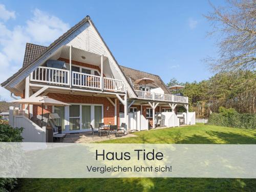 a house with a porch and a balcony at Entspannter Nordsee-Urlaub in naturnahen Ferienwohnungen im Haus Tide in Böhl
