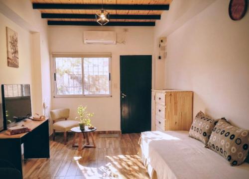 a bedroom with a bed and a desk and a window at Departamentos A&B in Resistencia