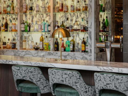 a bar with two chairs in front of a counter at Pullman Paris Tour Eiffel in Paris