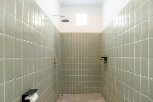 a bathroom with a shower with green tiles at Casa Lumina Canggu in Canggu
