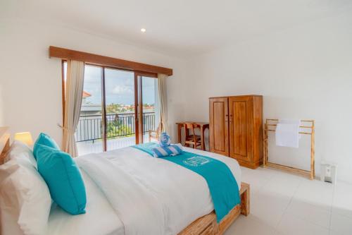 a bedroom with a large bed and a balcony at Casa Lumina Canggu in Canggu
