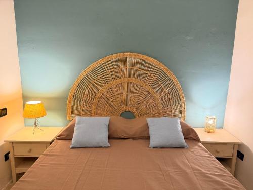 a bed with a large wicker headboard in a bedroom at Suite Del Borgo in Gallipoli